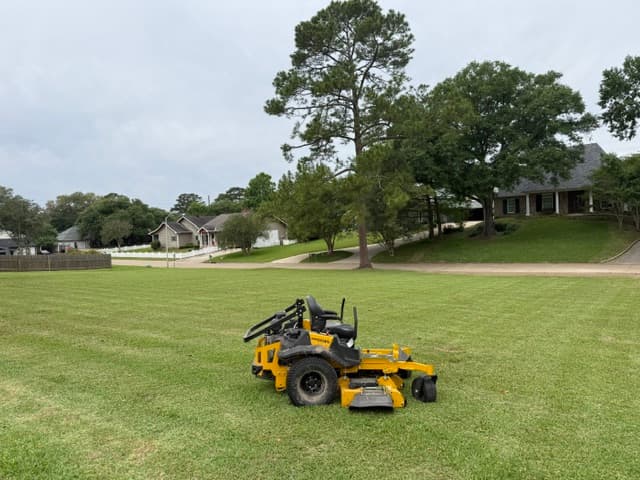 Zero-turn mower on freshly striped residential lawn Louisiana