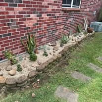 Completed succulent rock garden with stacked stone border
